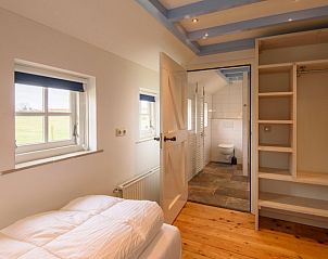 Slaapkamer met en suite badkamer in Het Goeie op Terschelling, Lies, met natuurlijke lichtinval.