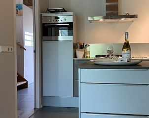 Stijlvolle keuken in vakantiehuis Castor in Oosterend, Terschelling, met wijnfles en glazen op het aanrecht.