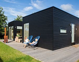 Florizand vacation home in Midsland North, Terschelling with modern veranda and green surroundings.