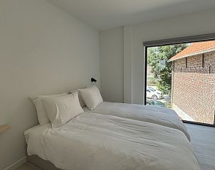 Lichte slaapkamer met uitzicht op het dorp in The View vakantiehuis in Gooik, Vlaams-Brabant.