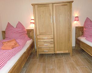 Vakantiehuis Ferienhof am Biberbach in Thringen biedt een knusse slaapkamer met houten accenten en uitnodigende ambiance.