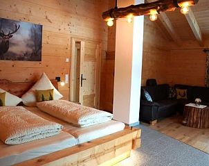 Slaapkamer Vakantiehuisje in Drachselsried, Beieren, Duitsland: sfeervol houten interieur met comfortabele zitgelegenheid.