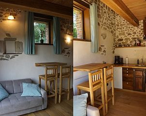 Charmante binnenruimte van Vakantiehuisje in Espinasse, Auvergne, met stenen muren en een warme houten afwerking.