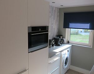 Moderne keuken van bungalow Helma in Ballum, Ameland met wasmachine en oven.
