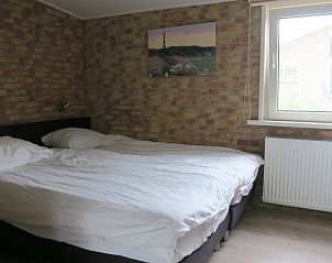 Ruime slaapkamer in vakantiehuis Helma, Ballum, Ameland met groot bed en raam.