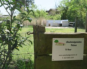Ingang van Helma bungalow in Ballum, Ameland met bord en groene omgeving.