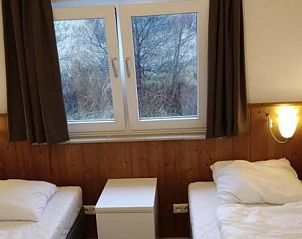 Gezellige tweepersoonsslaapkamer in Klavertje Vier bungalow, Buren, Ameland met uitzicht op de natuur.