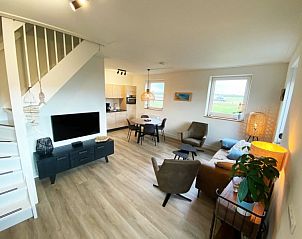 Stijlvolle woonkamer van De Miede, een vakantiehuis in Nes, Ameland met moderne inrichting en uitzicht op de natuur.