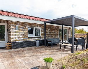 Veranda van vakantiehuis Nesserduinen 42D in Nes, Ameland met moderne zitruimte en overkapping.