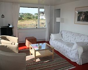 Gezellige woonkamer in Aurora vakantiehuis in Nes, Ameland met veel natuurlijk licht.