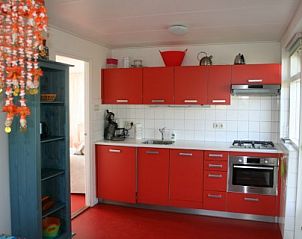 Moderne rode keuken in Aurora vakantiehuis in Nes, Ameland voorzien van alle gemakken.