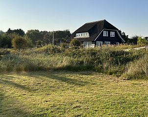 Landschap rondom Aurora vakantiehuis in Nes, Ameland met uitgestrekte grasvelden.