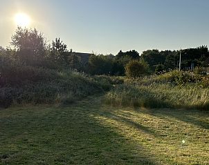 Zonovergoten tuin bij Aurora vakantiehuis in Nes, Ameland, ideaal voor buitenactiviteiten.