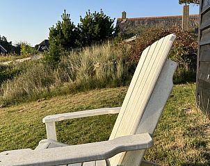 Comfortabele stoel in de tuin van Aurora vakantiehuis in Nes, Ameland, perfecte relaxplek.