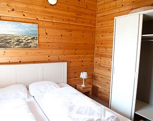 Gezellige slaapkamer in Ascona vakantiehuis, Nes, Ameland met houten interieur, ideaal voor rust op de Waddeneilanden.