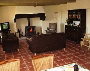 Rustieke woonkamer van Ti Cos Kaourintine, vakantiehuis in Briec de l'Odet, Bretagne met warme open haard en charmante meubels.