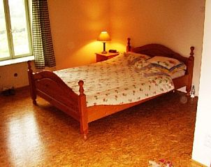 Landelijke slaapkamer van vakantiehuis Ti Cos Kaourintine, Briec de l'Odet, Bretagne, met houten bed en knusse ambiance.