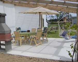 Verken de buitenruimte van Ti Cos Kaourintine, een vakantiehuis in Briec de l'Odet, Bretagne, compleet met een sfeervol terras en hangstoel.