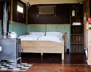 Slaapkamer van BoerenBed Tent, een vakantiehuis in Scaer, Bretagne, Frankrijk, met houten interieur en landelijke charme.