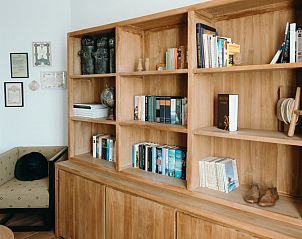 Stijlvolle leeshoek in Maison Patisson, vakantiehuis in Kasterlee, met houten boekenkast en comfortabele stoel, Antwerpen, Belgi.