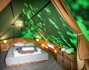 Sfeervolle glamping lodge in Bonaventure Village, Senonches, Centre, Frankrijk met een uitnodigende slaapruimte en natuurlicht.