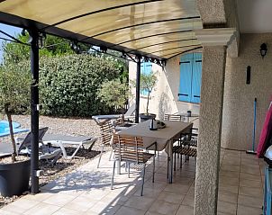 Ervaar de rust op het terras van Le Canard Bleu 5* vakantiehuis in Siran-Najac, Languedoc, met comfortabele zitplekken en zwembadzicht.