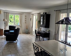 Elegante leefruimte in Le Canard Bleu 5* vakantiehuis, Siran-Najac, met stijlvolle inrichting en toegang tot zonnig terras.