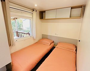 Slaapkamer van Chalet Toppy nr 5 in Argels-sur-Mer, Frankrijk, een stacaravan met rustgevend uitzicht op de omgeving.