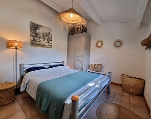 Rustieke charme in de slaapkamer van vakantiehuis Aioli, Montbrun-des-Corbires, Languedoc, met een uitnodigend bed en warme accenten.