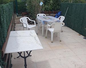 Buitenleven op het terras van location appartement 5 personnes in La Grande-Motte, Languedoc-Roussillon, omringd door groene natuur.
