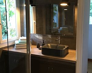 Elegante badkamer van Vakantiehuis in Arles Sur Tech, Arles-sur-Tech, Languedoc/Roussillon, Frankrijk, voorzien van moderne wastafel en verlichting.