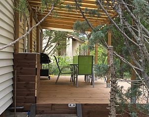 Chalet Jadorel in Vacquieres, Languedoc, Frankrijk, met een uitnodigend terras omgeven door weelderige bomen en rustgevende omgeving.