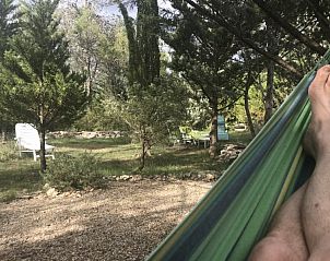 Chalet Jadorel biedt een serene ontsnapping in Vacquieres, Languedoc, met een hangmat tussen de bomen.