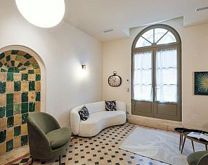 Elegant interieur van Huisje in Pezenas, vakantieverblijf in Languedoc, Frankrijk, met een charmante boog en uitnodigende zithoek.