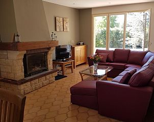 Villa Chasanka in Moissac-Bellevue, Provence, biedt een sfeervolle woonkamer met grote ramen en een knusse zithoek.