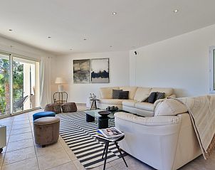 Comfortabele woonkamer in Villa Azur, een vakantiehuis in Sainte-Maxime, Provence, met grote ramen en uitzicht op groene omgeving.