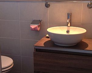 Gezellige badkamer in Vakantiehuis Montfermier, Frankrijk, voorzien van eigentijdse wastafel en houten kast.