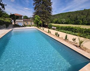 Sfeervolle eetruimte in Vakantiehuisje in Grezels, Midi / Pyrenees, met karakteristieke open haard en kleurrijke decoratie.