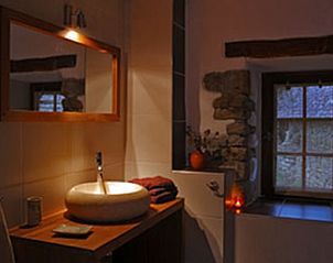 Moderne badkamer in Vakantiehuis in Oust, Midi/Pyrenees, Frankrijk, met stenen muurdetails en een elegant wastafelontwerp.