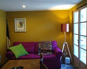 Sfeervolle zithoek in het vakantiehuis Source bien-aime, Chanac, Rhone-Alphes, Frankrijk, met uitnodigende bank en natuurlijk licht.