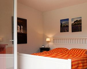 Lichte slaapkamer in Domaine Les Rives de lArdche, Vallon-Pont-d'Arc, Frankrijk, met moderne inrichting en toegang tot de tuin.