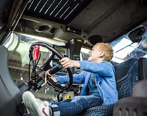 Kind beleeft plezier in tractor bij Akkermanshof vakantiehuis in Bocholt, Limburg, Belgi.