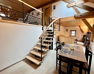 Stijlvolle eetruimte in Huisje in LE SAULCY, vakantiehuis in Le Saulcy, Lotharingen, met open trap en houten balken.