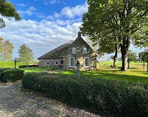Buitenkant van Vakantiehuisje in Piaam omgeven door groene natuur en bomen, ideaal voor een ontspannen verblijf aan de Friese meren.