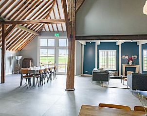 Open leefruimte in Vakantiehuisje in Piaam met uitzicht op groene velden, perfect voor een rustige vakantie aan het IJsselmeer.