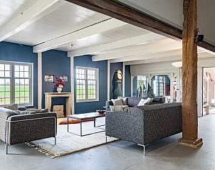 Stijlvolle woonkamer in Vakantiehuisje in Piaam met moderne meubels en uitzicht op de natuur van de Friese meren.