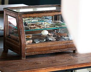 Decoratieve vitrinekast in Vakantiehuisje in Piaam met lokale vondsten, een unieke toevoeging aan het interieur aan de Friese meren.