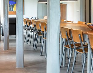 Lange eettafel in Vakantiehuisje in Piaam, omringd door houten balken, perfect voor diners met uitzicht op de Friese meren.