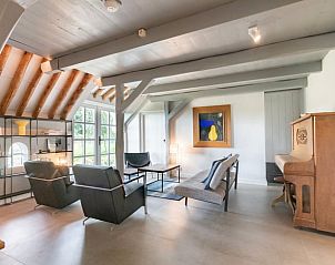 Knusse zithoek in Vakantiehuisje in Piaam met uitzicht op de tuin, ideaal voor een ontspannen verblijf aan het IJsselmeer.