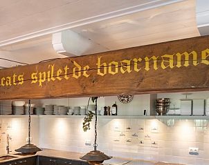 Houten balk met Friese tekst in de keuken van Vakantiehuisje in Piaam, een authentieke touch aan de Friese meren.